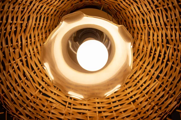 Tavanda ahşap bir abajur olan güzel bir lamba.