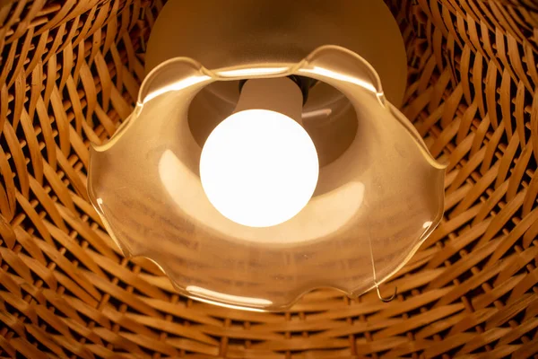 Tavanda ahşap bir abajur olan güzel bir lamba.