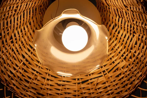 Tavanda ahşap bir abajur olan güzel bir lamba.