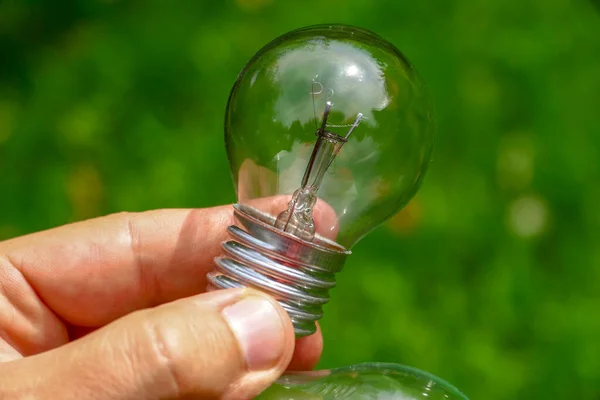 Gloeilamp Vermogen 100 Watt Lamp Hand Een Gekleurde Achtergrond — Stockfoto