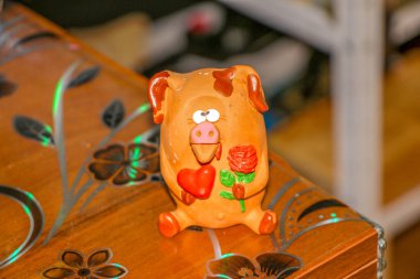 Bir çiçeğe aşık şaşı gözlü domuz yavrusu ve pençelerinde kırmızı bir kalp Sevgililer Günü 'nü ve 8 Mart Sevgililer Günü' nü, Anneler Günü 'nü kutluyor.