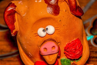 Bir çiçeğe aşık şaşı gözlü domuz yavrusu ve pençelerinde kırmızı bir kalp Sevgililer Günü 'nü ve 8 Mart Sevgililer Günü' nü, Anneler Günü 'nü kutluyor.