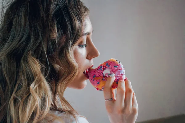 Κοντινό Πλάνο Κορίτσι Λευκό Φόντο Τρώει Ένα Ροζ Ντόνατ — Φωτογραφία Αρχείου