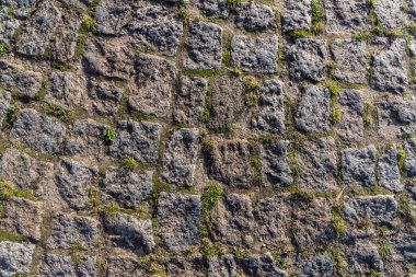 Granit sert taş duvarlar. Kaba gri taş dokusu. Dekoratif duvar kare taşlar şeklinde serilmiştir..