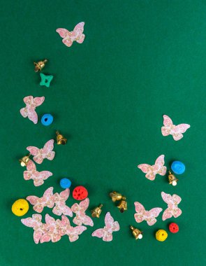 Yeşil arka planda dekoratif çerçeve. El yapımı el sanatları. Davetiyeler, kartpostallar, selamlar için kartpostal. Yazmak için boş alanı olan oval çerçeve. Dekoratif kelebekler, çanlar, renkli yuvarlaklar.