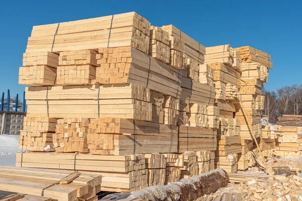 Kereste ve kirişleri hazırlayın. Kereste yığını, bir ev inşa etmek için hazırlanmış ahşap bir kiriştir. Ahşap kirişler deposu. Açık alanda paketlenmiş kereste. Testere kerestesi üretimi.