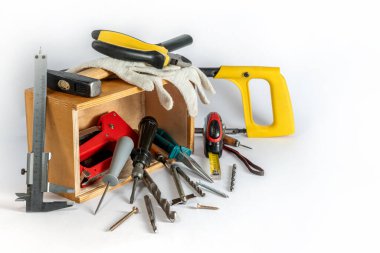 Beyaz arka planda tahta alet kutusu. Tamir aletleri. İnşaat aletleri ve asansörler kutunun içinde ve yanında. Onarım için bir sürü farklı alet kutunun içinde duruyor..