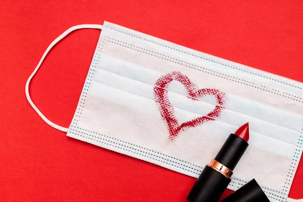 배경에 립스틱으로 심장으로 보호하는 의료용 마스크 립스틱 튜브가 마스코 발렌타인의 — 스톡 사진