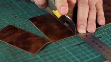 Tanner 'ın ellerine yaklaş ve deriyi bıçakla kes. El yapımı deri ürünleri. Hobi konsepti. Yavaş çekim.