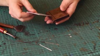 Gerçek deriden yapılmış ürünler üretme süreci. Tamamlanmış deri kart sahibinin tanıtımı. Hobi konsepti. Yavaş çekim, yakın çekim..