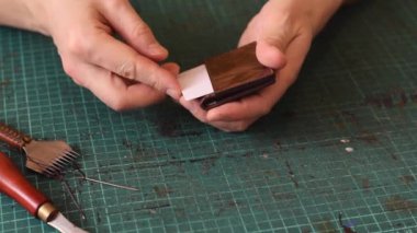 Gerçek deriden yapılmış ürünler üretme süreci. Tamamlanmış deri kart sahibinin tanıtımı. Hobi konsepti. Yavaş çekim, yakın çekim..