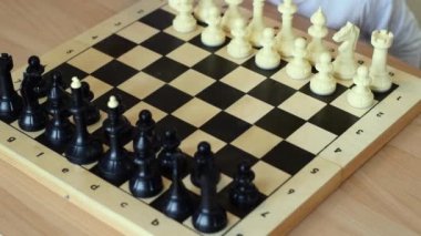 Küçük bir çocuk evde babasıyla satranç oynuyor. Ortak aile eğlencesi. Satranç oynamayı öğreniyor. Erken çocukluk gelişimi..