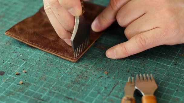 革のカードホルダーを製造するプロセス金属製のパンチャーで革の作品に穴を開ける 手作りの革製品 趣味のコンセプト — ストック動画
