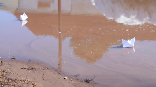 Zwei Weiße Papierboote Schwimmen Einer Schlammigen Frühlingspfütze Frühlingskonzept Kinderfreizeit Nahaufnahme — Stockvideo