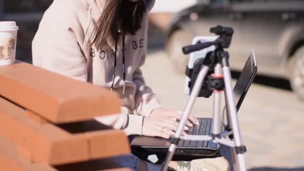 Brunette Κορίτσι Κάθεται Ένα Παγκάκι Του Δρόμου Εργάζονται Φορητό Υπολογιστή — Αρχείο Βίντεο