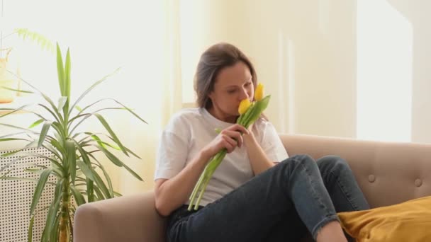Attraktive Kaukasische Frau Lächelt Und Genießt Den Duft Gelber Tulpen — Stockvideo