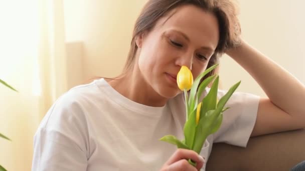 Atractiva Mujer Caucásica Sonríe Disfruta Los Aromas Los Tulipanes Amarillos — Vídeos de Stock