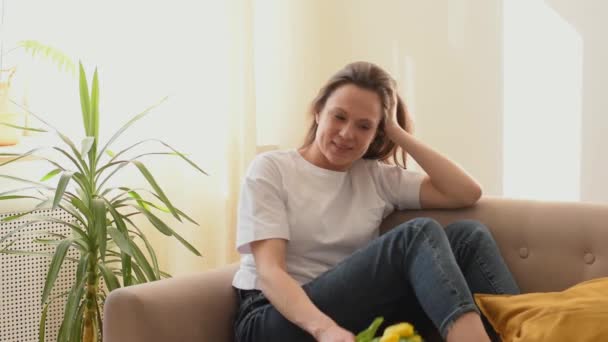 Atraktivní Běloška Usmívá Vychutnává Vůni Žlutých Tulipánů Interiéru Den Matek — Stock video