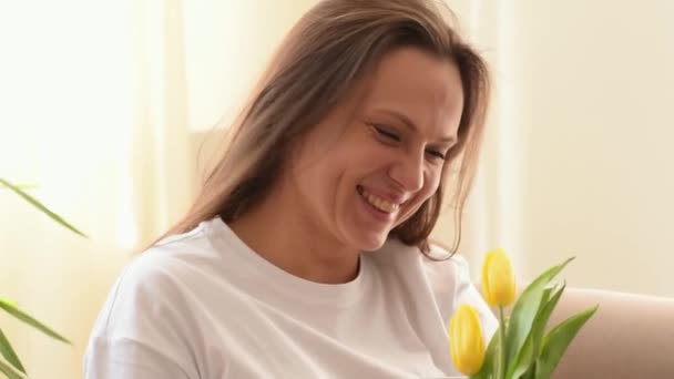 Atractiva Mujer Caucásica Sonríe Disfruta Los Aromas Los Tulipanes Amarillos — Vídeo de stock
