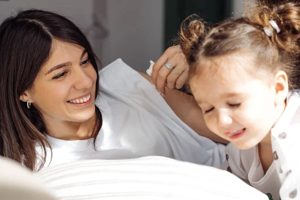 Uma Jovem Cabelos Escuros Mestiça Joga Cama Com Sua Filhinha — Fotografia de Stock