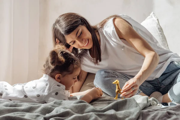 Uma Jovem Cabelos Escuros Mestiça Joga Cama Com Sua Filhinha — Fotografia de Stock