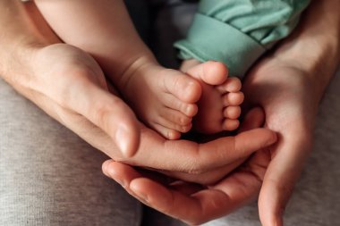 Bebek ayakları babalarının elinde. Babalar Günü konsepti. Yakın plan, seçici odaklanma..