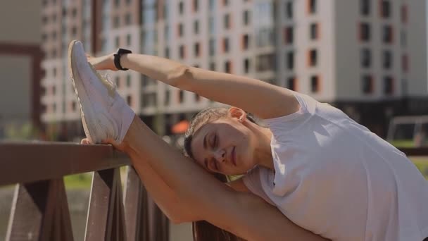 Pozytywna Wysportowana Młoda Kobieta Shircie Spodenkach Tenisówkach Rozciągająca Nogę Molo — Wideo stockowe