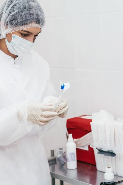 A medical worker opens a package with a cotton swab for a coronovirus test.Medical and coronavirus concept.