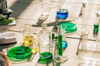 Laboratuvardaki beyaz bir masada çok renkli çözeltilere sahip kimyasal laboratuvar yemekleri. Okul konseptine. Genç bilim adamları. Anaokulu ve çocukların okul eğitimi..