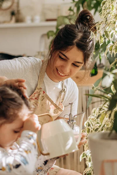 Mujer Familia Raza Mixta Con Hija Pequeña Está Regando Las Imagen de archivo