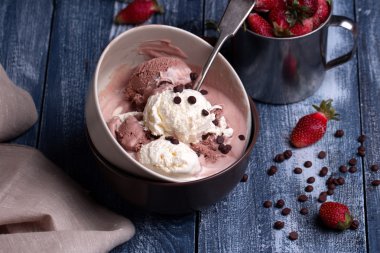 Vanilyalı ve çikolatalı dondurma taze çilek ile bir top şeklinde.