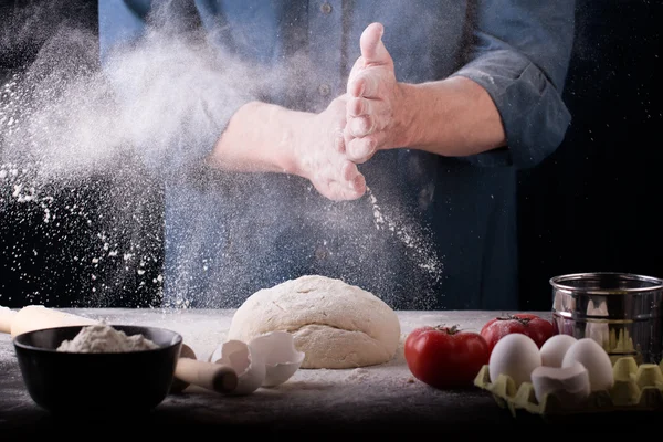 Baker prepares the dough on table