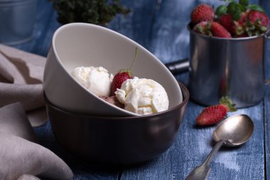 Vanilyalı ve çikolatalı dondurma taze çilek ile bir top şeklinde.