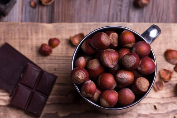 Morceaux de chocolat avec diverses noix sur une table en bois — Photo