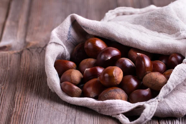 Kastanjes op de oude houten tafel — Stockfoto