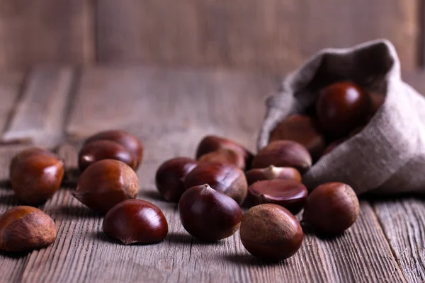 Castanhas na velha mesa de madeira — Fotografia de Stock