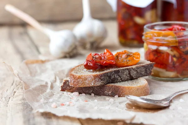 Pane fresco con pomodori secchi su un tavolo di legno . — Foto Stock