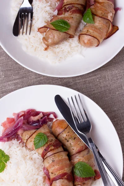 Salsicce bavaresi alla griglia con riso e menta su piatto bianco — Foto Stock