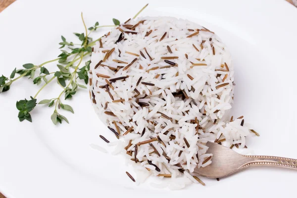 Mixed cooked rice with thyme on white plate — Stock Photo, Image