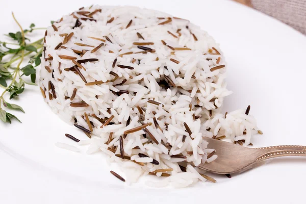 Mixed cooked rice with thyme on white plate — Stock Photo, Image