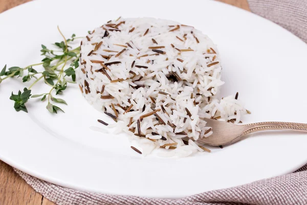 Mixed cooked rice with thyme on white plate — Stock Photo, Image