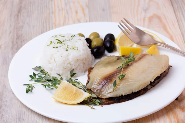Fried tilapia served with rice and herbs — Stock Photo, Image