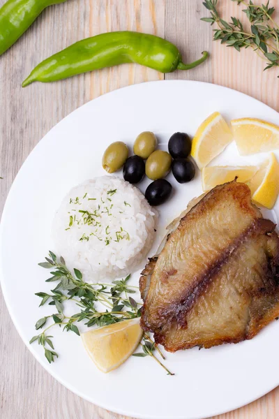 Fried tilapia served with rice and herbs — Stock Photo, Image