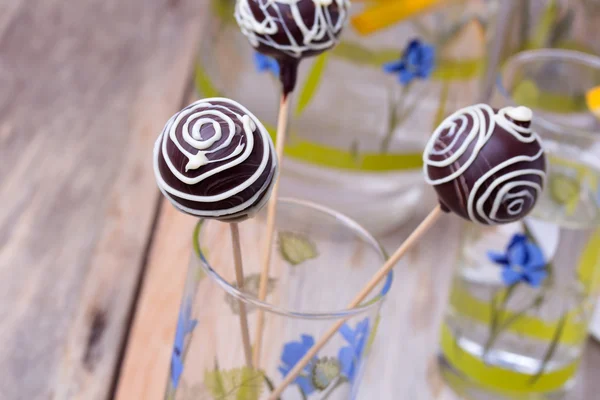 Pastel de chocolate aparece en los palos en vidrio, fondo de madera — Foto de Stock