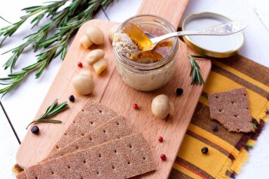 Kavanoz ve crispbread ahşap kesme tahtası üzerinde tavuk pate