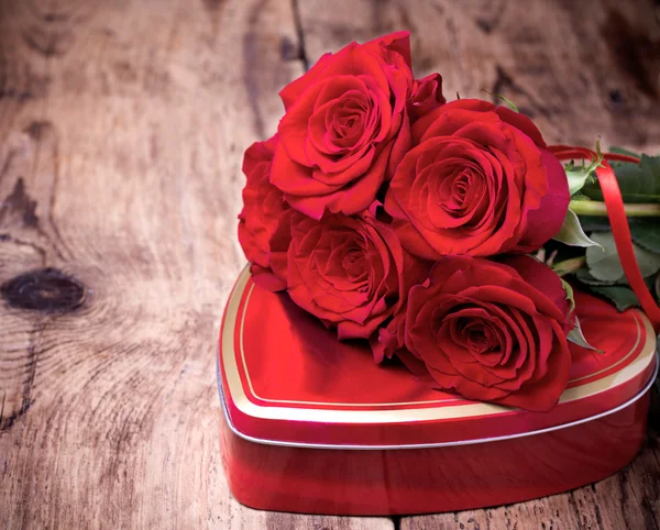 Gift box and bouquet of roses on wooden background. — Stock Photo, Image