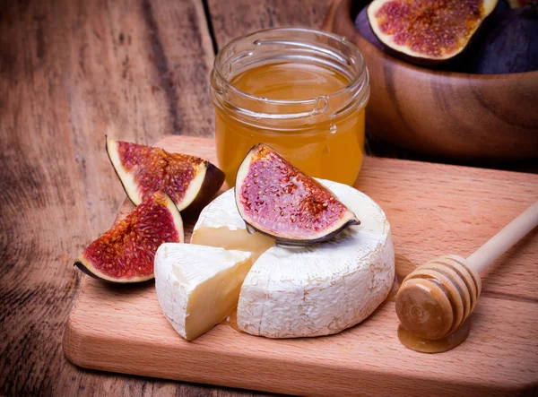 Formaggio Camembert con miele e fichi su una tavola di legno . — Foto Stock