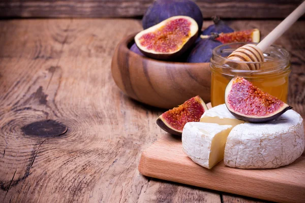 Formaggio Camembert con miele e fichi su una tavola di legno . — Foto Stock