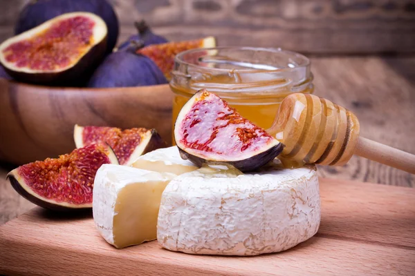 Camembert mit Honig und Feigen auf einem Holzbrett. — Stockfoto