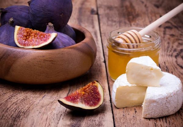 Camembert mit Honig und Feigen auf einem Holzbrett. — Stockfoto